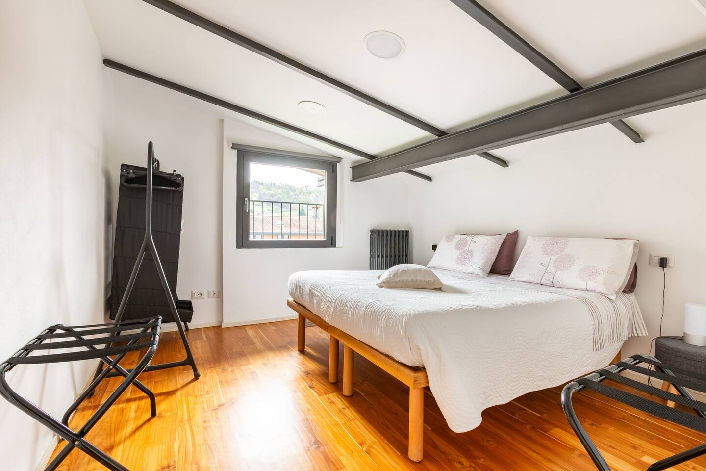 Double bedroom at La Casa degli Ulivi featuring wooden parquet flooring, exposed beams and panoramic window - Modern and cozy design with quality bedding
