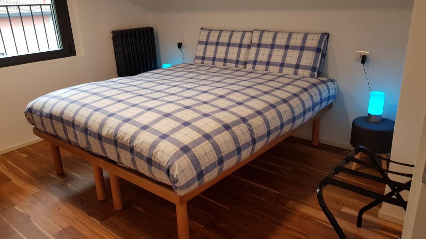 Camera da letto matrimoniale de La Casa degli Ulivi con pavimento in parquet e vista sul giardino di ulivi